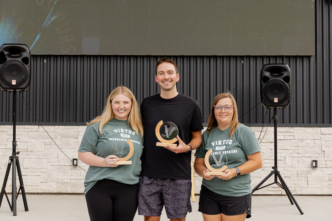 Three Virtus Value Awards recipients holding their awards at Virtus Days.